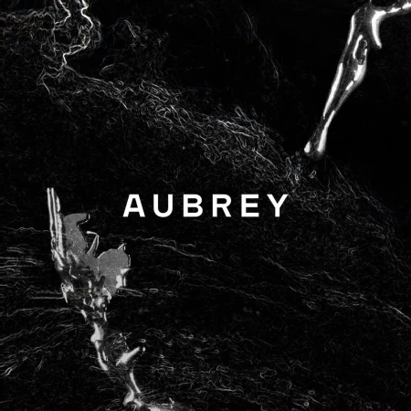 High contrast black and white abstract graphic with metallic chrome details and the word AUBREY centered in white uppercase text.