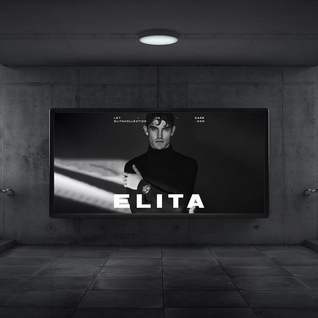 Black and white fashion advertisement featuring a male model wearing a black turtleneck sweater, displayed on a billboard screen.