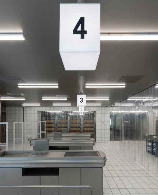 Empty supermarket checkout lanes with number signs and bright lights, creating a modern and minimalist ambiance for retail shopping.