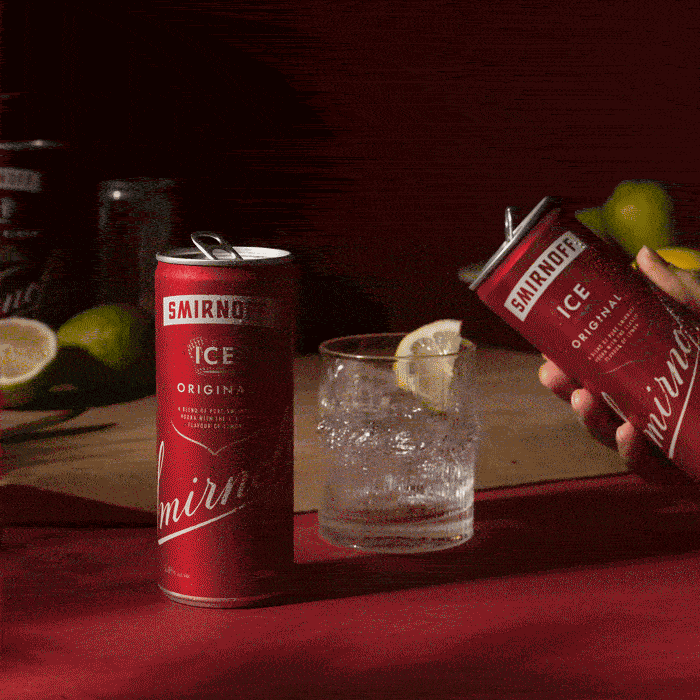 Smirnoff Ice Original beverages feature a can, a glass with ice and lemon, and limes against a dark red background.