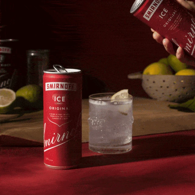 Smirnoff Ice Original beverages feature a can, a glass with ice and lemon, and limes against a dark red background.