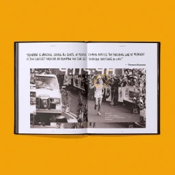An open book displaying black and white collage photography of runners and a vehicle against a solid yellow background.