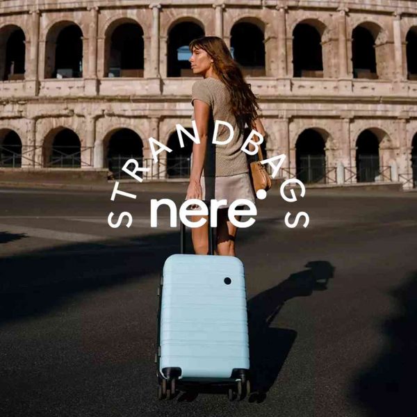 Woman pulling a light blue rolling suitcase on a street near the Colosseum in Rome. Travel and tourism, cityscape.
