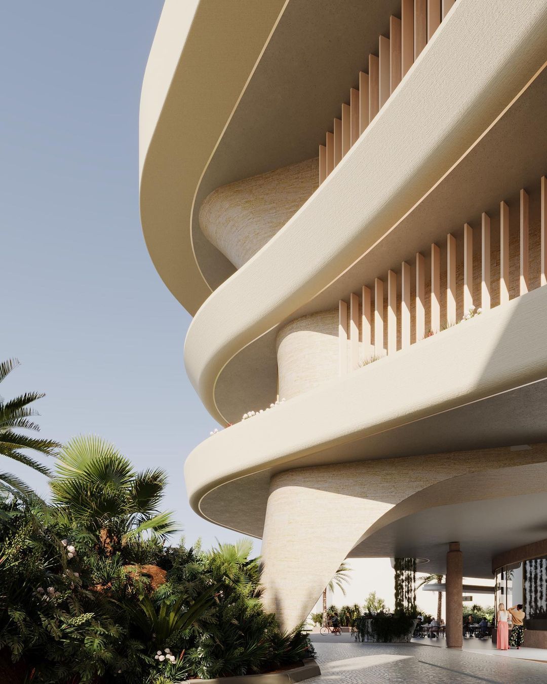 Exterior of modern architectural design building with curved balconies and beige facade, set against a blue sky and tropical vegetation.