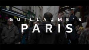 A video still showcases pedestrians walking along a city street with text overlayed, creating a candid and vibrant urban scene.
