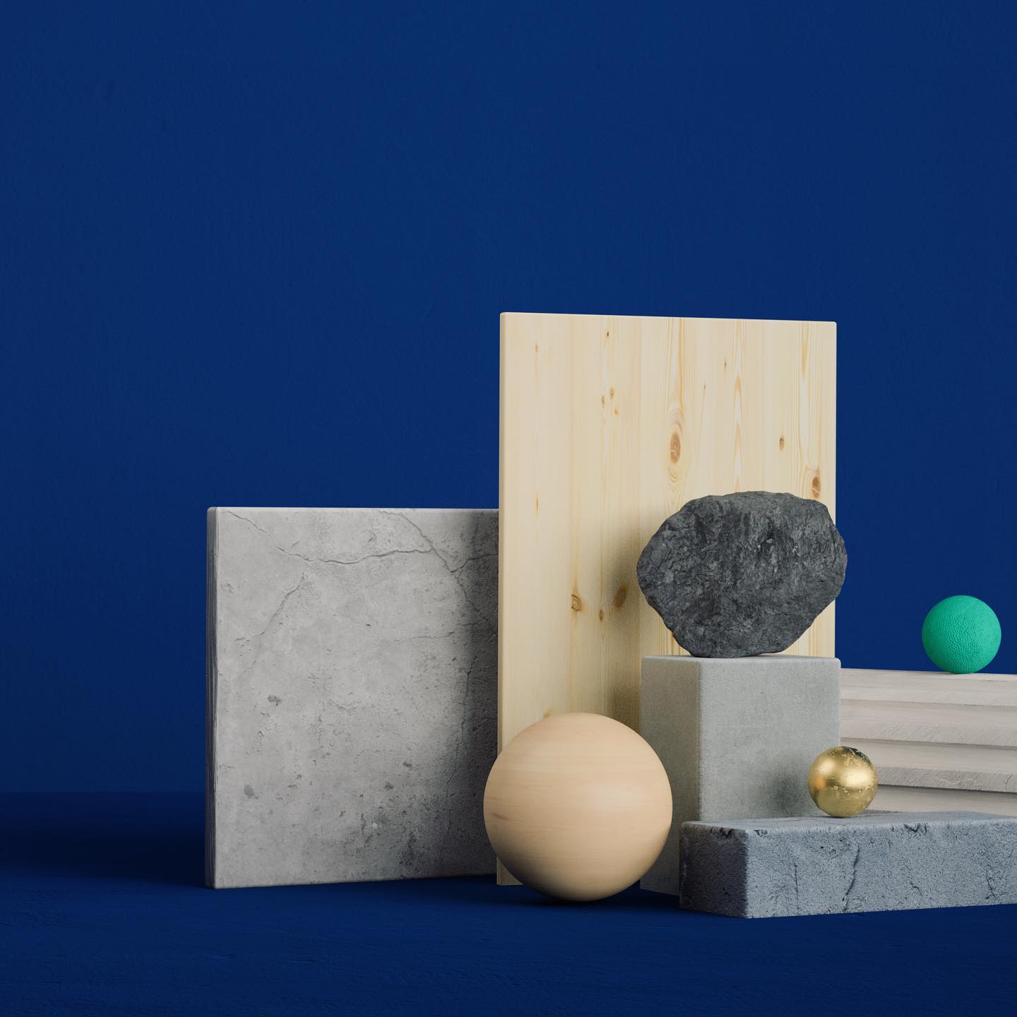 Still life of wood, concrete, and stone blocks, spheres, and geometric shapes in varied textures against a dark blue backdrop.