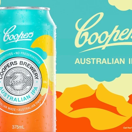 Eye-level close-up of a Cooper's Australian IPA beer can featuring shades of aqua, yellow, and orange and a graphic mountain range background.