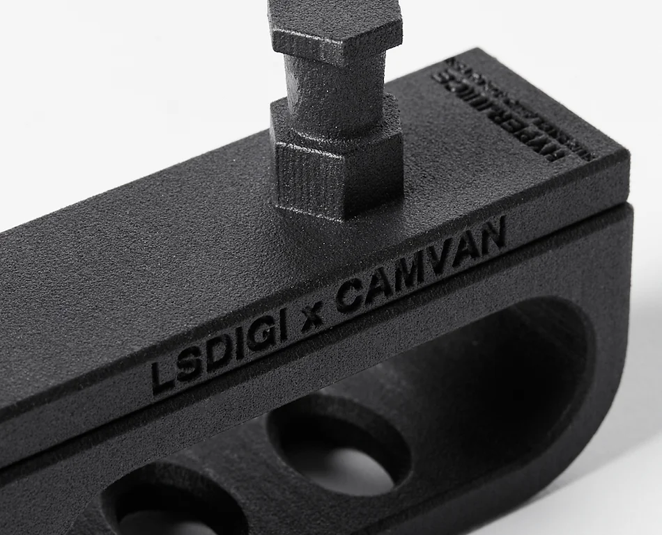 Close-up of a black metal mounting bracket with the text 'LSDIGI x CAMVAN' engraved on the side, set against a plain white background.