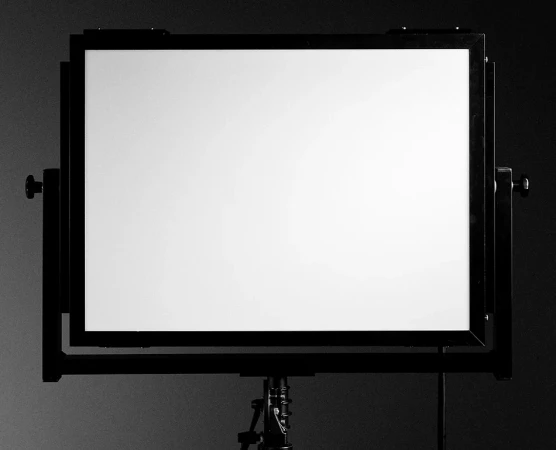 Studio lighting setup features a large rectangular softbox with a black frame and a white diffusion panel, mounted on an adjustable stand in a gray studio.
