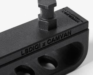 Close-up of black metal photo equipment clamp with embossed text against a white background