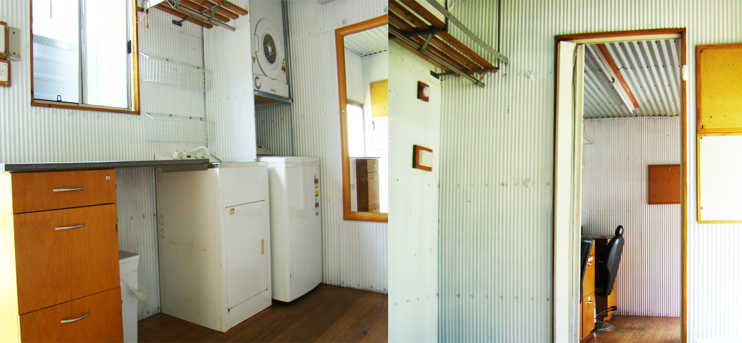 View of a bright, minimalist interior featuring white corrugated metal walls, wooden floors, and various appliances and furniture.