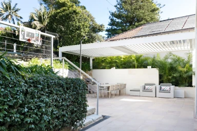 Modern outdoor patio and dining area with a white louvered pergola in Sydney, captured by The Scout Group.
