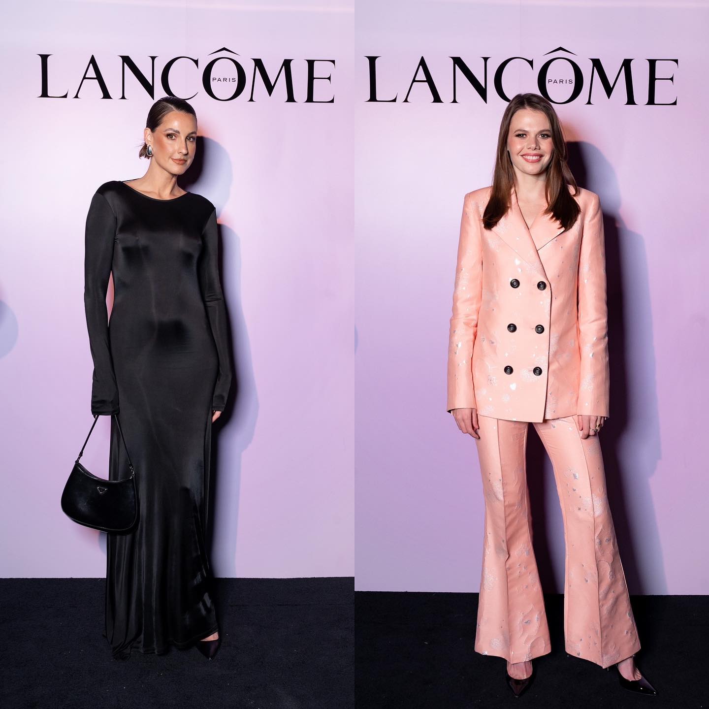 Two women pose in formal wear at Lancome event. One wears a sleek black gown and the other wears a light pink suit.