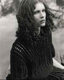 Monochrome portrait of a model with long curly hair wearing a textured dark knit sweater outdoors in Sydney.
