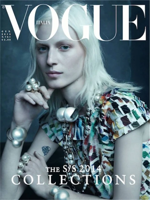 Vogue Italia cover featuring a model with blonde hair, wearing pearl jewellery and a patterned top against a grey background.
