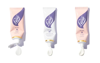 Three skincare tubes standing vertically against a white background with cream squeezing out of their nozzles.
