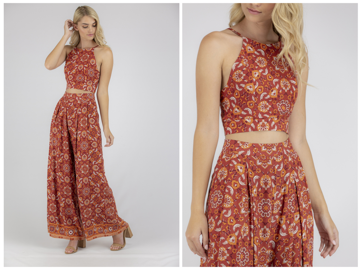 A slender model with blond hair poses in a rust-orange crop top and palazzo pants with a floral pattern on a white background.