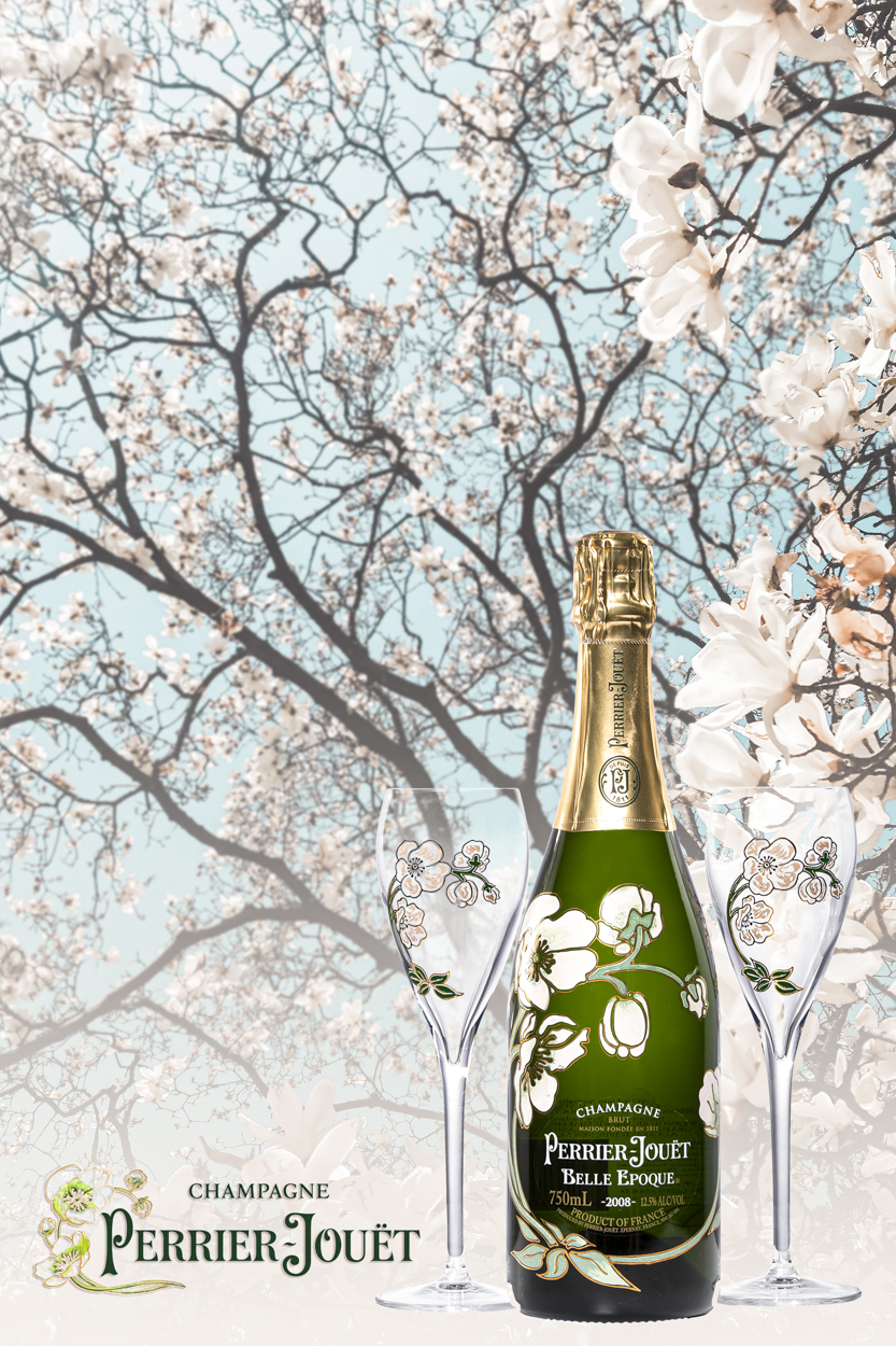 Bottle of Perrier-Jouët champagne and two champagne flutes are displayed against a soft background of flowering branches.