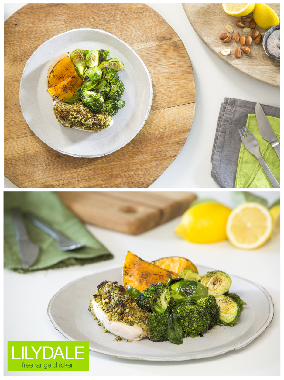 Overhead shot of a plate with chicken, sweet potato, and brussel sprouts on a wooden board, showcasing healthy food photography.