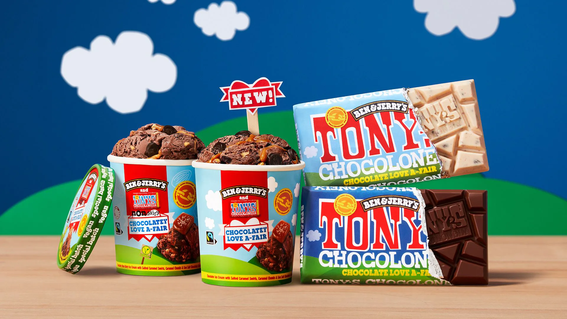Two pints of Ben & Jerry's ice cream next to Tony's Chocolonely chocolate bars against a blue background with cartoon clouds.