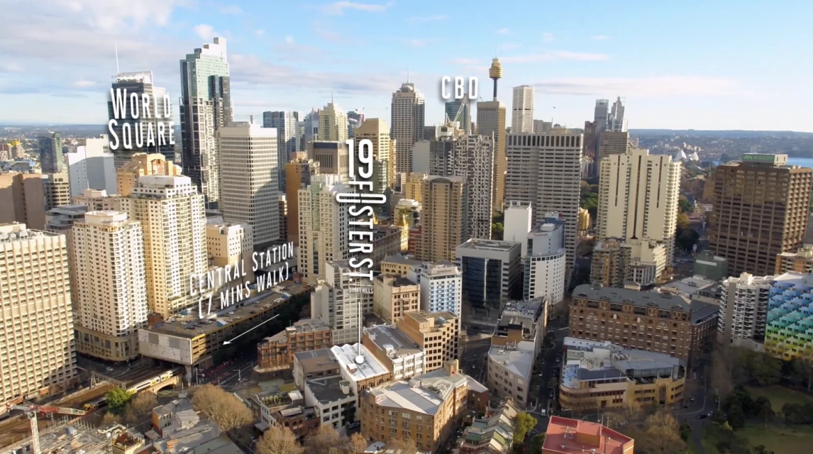 Aerial view of Sydney's cityscape featuring high-rise buildings, World Square, and the CBD under a bright sky, creating an urban panorama.