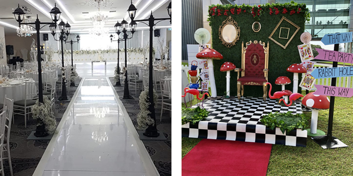 Indoor wedding event space with bright white flooring, black lamp post decorations, and dining tables set for a formal event, plus a party decoration.