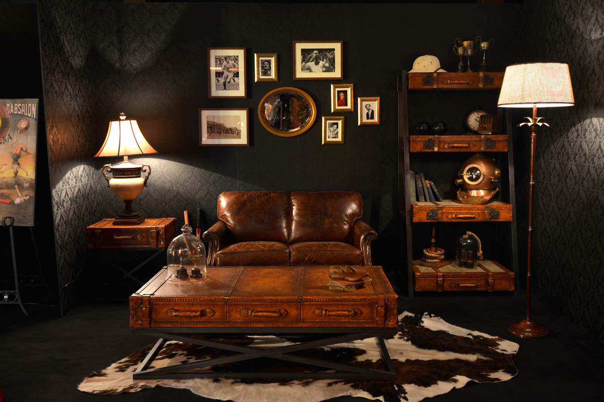 Living room interior with leather sofa and coffee table, flanked by lamps, against a dark wallpaper and black background.