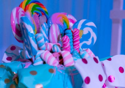 Eye-level medium shot of assorted colorful candies and lollipops, arranged together to create a visually striking display.