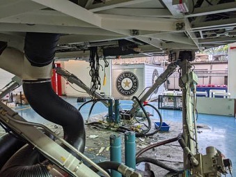 Underside view of mechanical aircraft landing gear, revealing the detailed structure and components of the system.