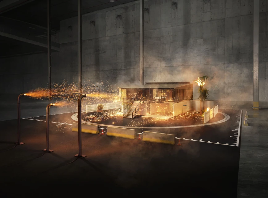 Modern architectural model under simulated fire with concrete walls and copper pipes spraying sparks in a dark, dramatic setting.