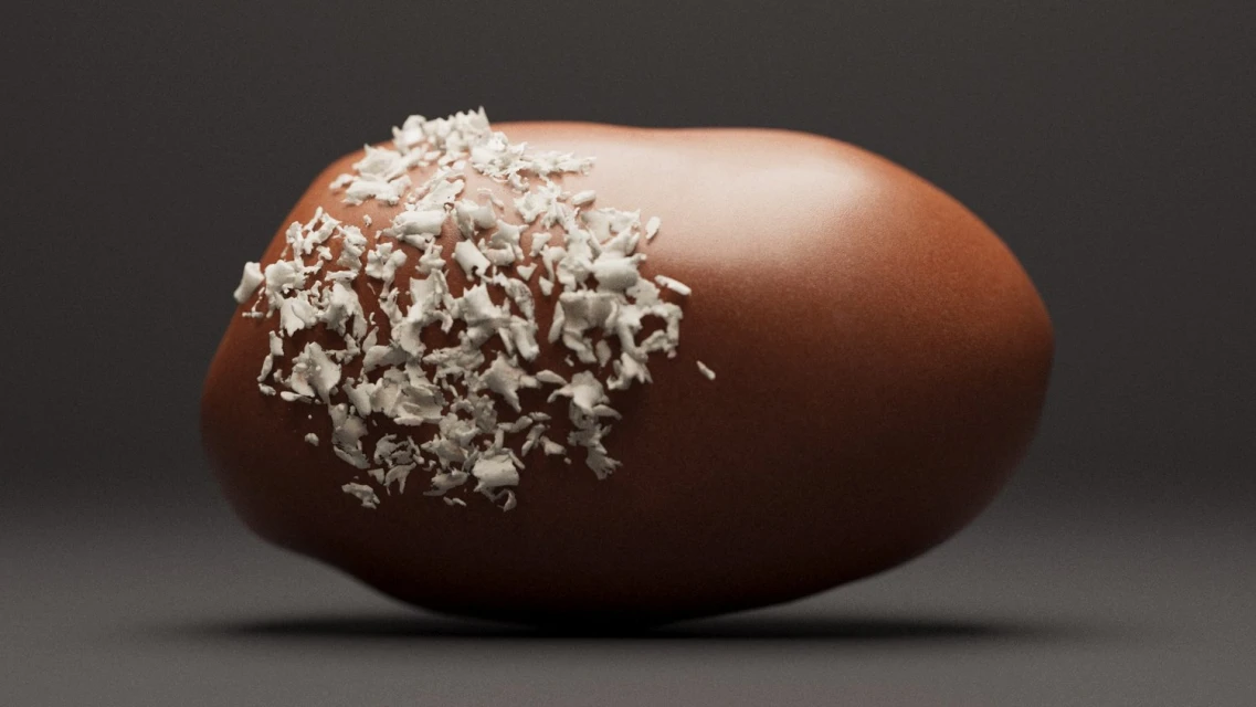 Close-up of a brown candy truffle, partially covered in white shredded coconut, set against a dark gray background in a studio setting.