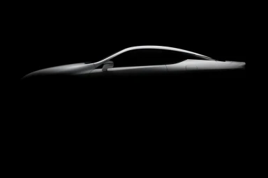 Sleek silver sports car silhouette highlighted against a deep black background by d1 Studios in Sydney.