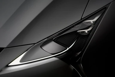 Close-up of a modern dark car headlight with angular design and glowing LED accent line by d1 Studios in Sydney
