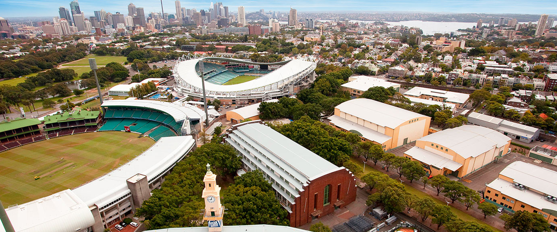 Aerial view of Sydney, Australia, showcasing sports stadiums, buildings, and cityscape, with a focus on architecture and urban environment.