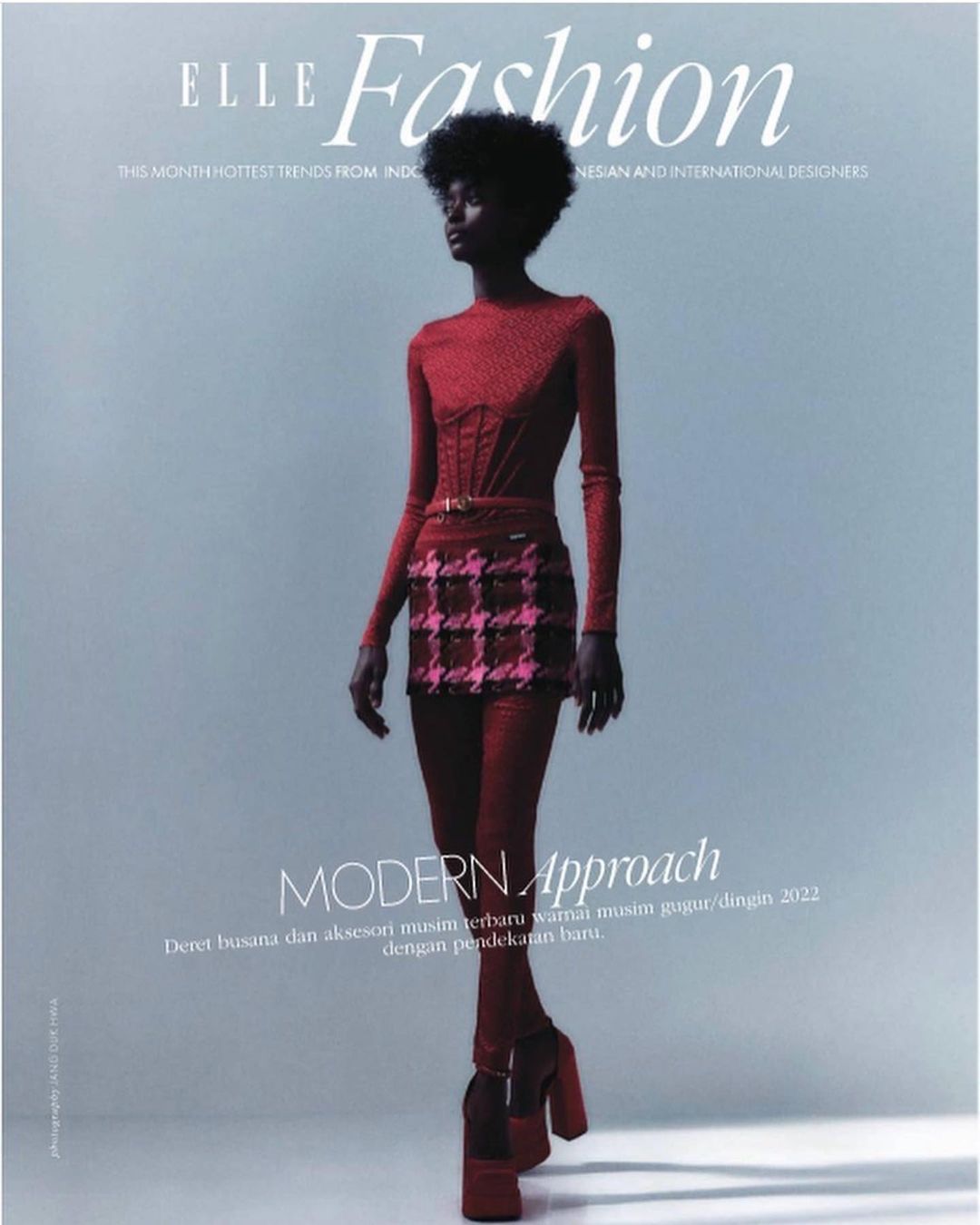 Elle Fashion magazine cover featuring a full-length shot of a woman in a red long-sleeved top, plaid mini skirt, red tights, and heels.