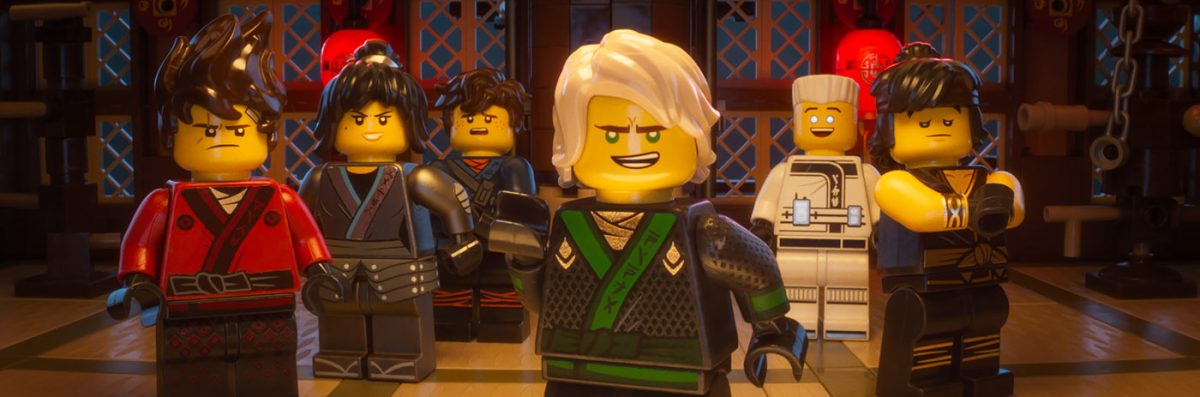 Group of Lego Ninjago figures in a room setting, featuring characters in colorful ninja outfits with a focus on a central figure.