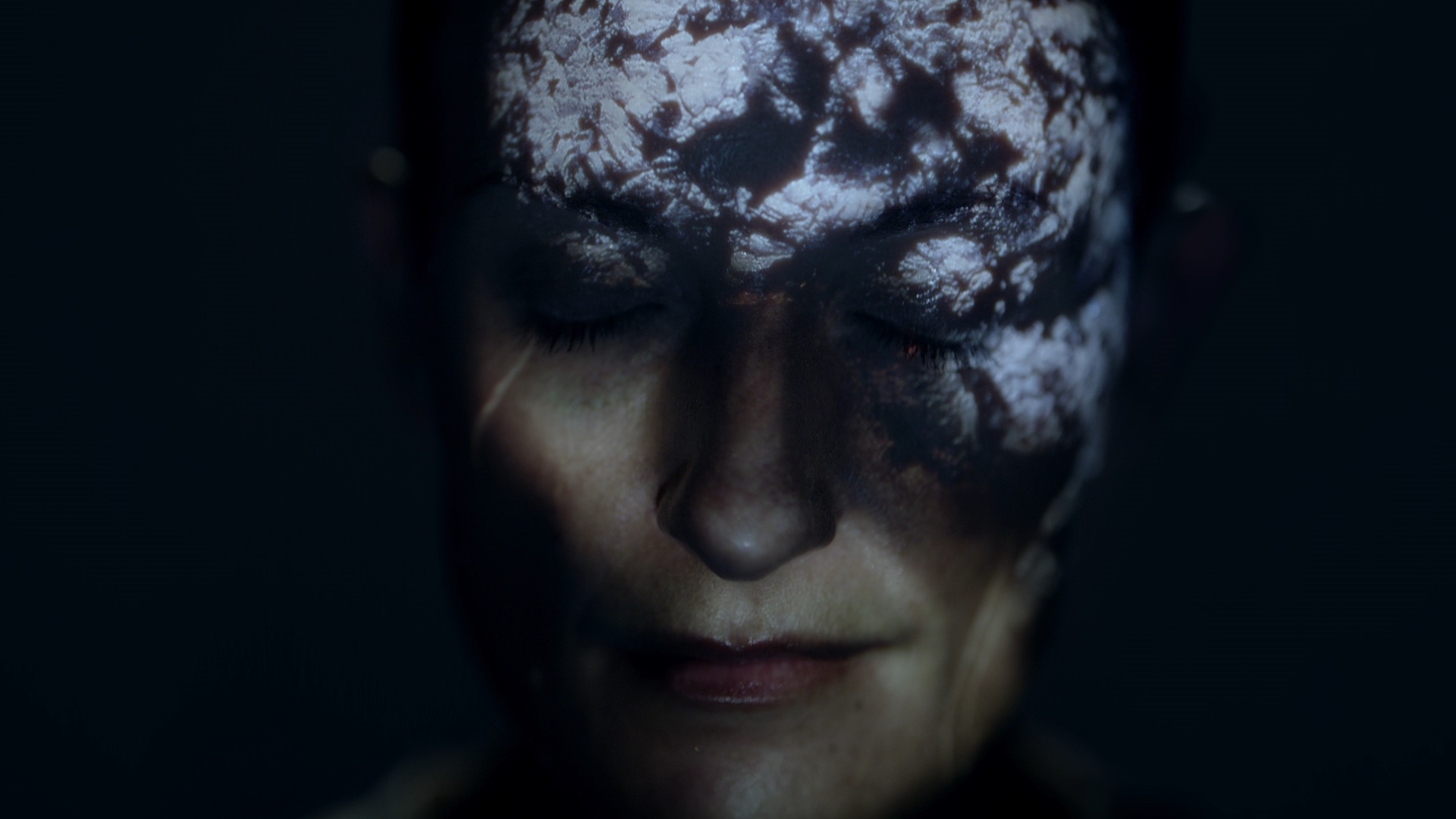 Close-up of a woman's face with closed eyes and abstract light patterns across her face in a dark, moody, and dramatic atmosphere.
