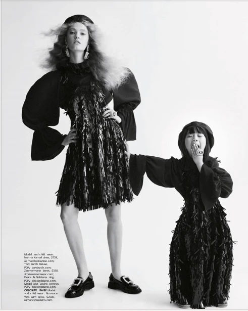 Monochrome fashion editorial image featuring a tall model and a child model in black dresses standing against a white seamless backdrop.