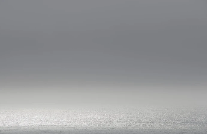 Minimalist landscape seascape with grey overcast sky over a calm ocean horizon photographed by Adam Kola in Sydney