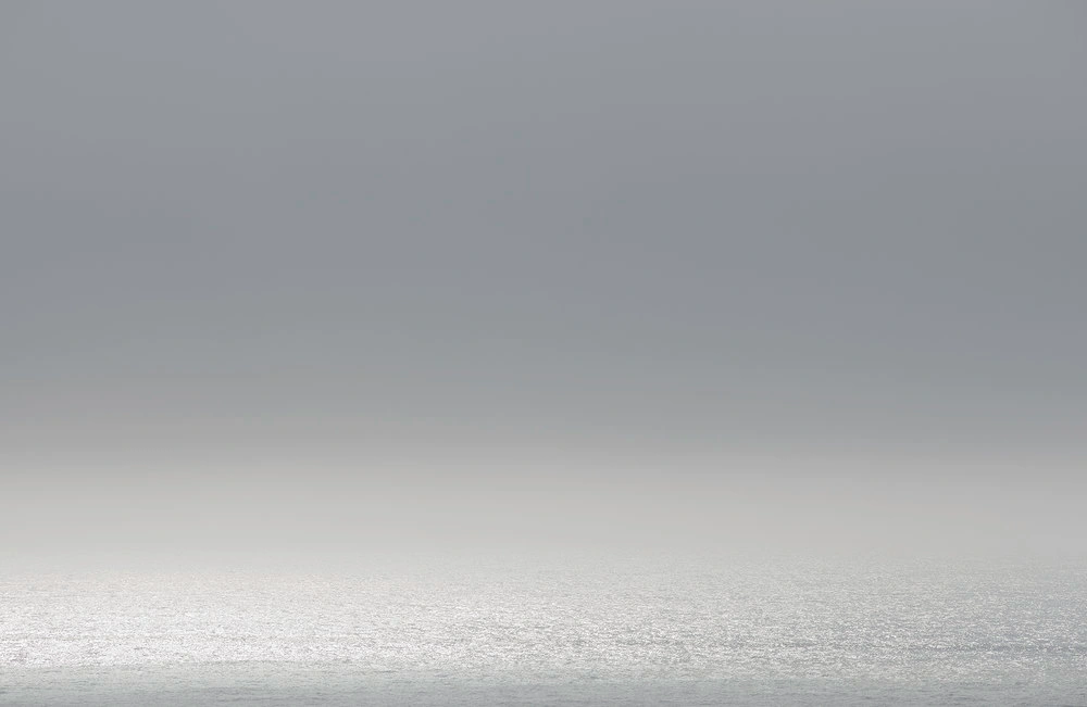 Minimalist landscape seascape with grey overcast sky over a calm ocean horizon photographed by Adam Kola in Sydney