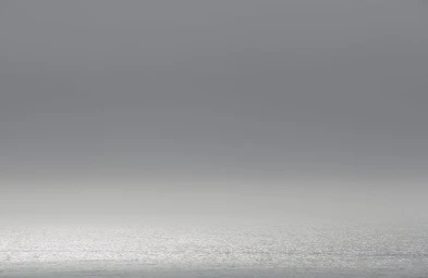 Minimalist landscape seascape with grey overcast sky over a calm ocean horizon photographed by Adam Kola in Sydney