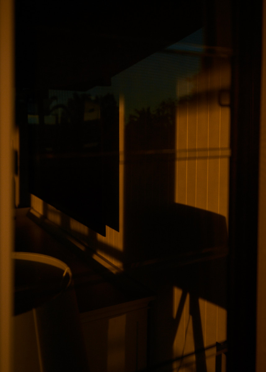 Abstract architectural exterior view featuring a cream-colored wall in a low-light setting, creating an atmosphere of mystery and intrigue.