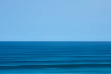 Minimalist long exposure seascape photography by Alex Brunton featuring horizontal bands of blue ocean and clear sky