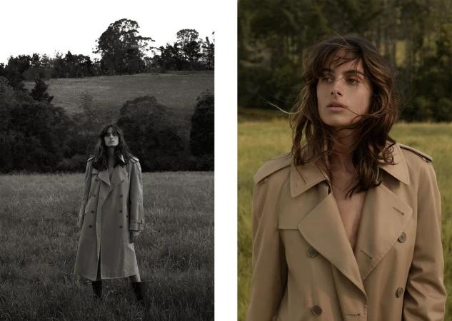 Portrait of a woman wearing a camel trench coat in a grassy meadow, featuring make-up by Lachlan Wignall in Sydney.