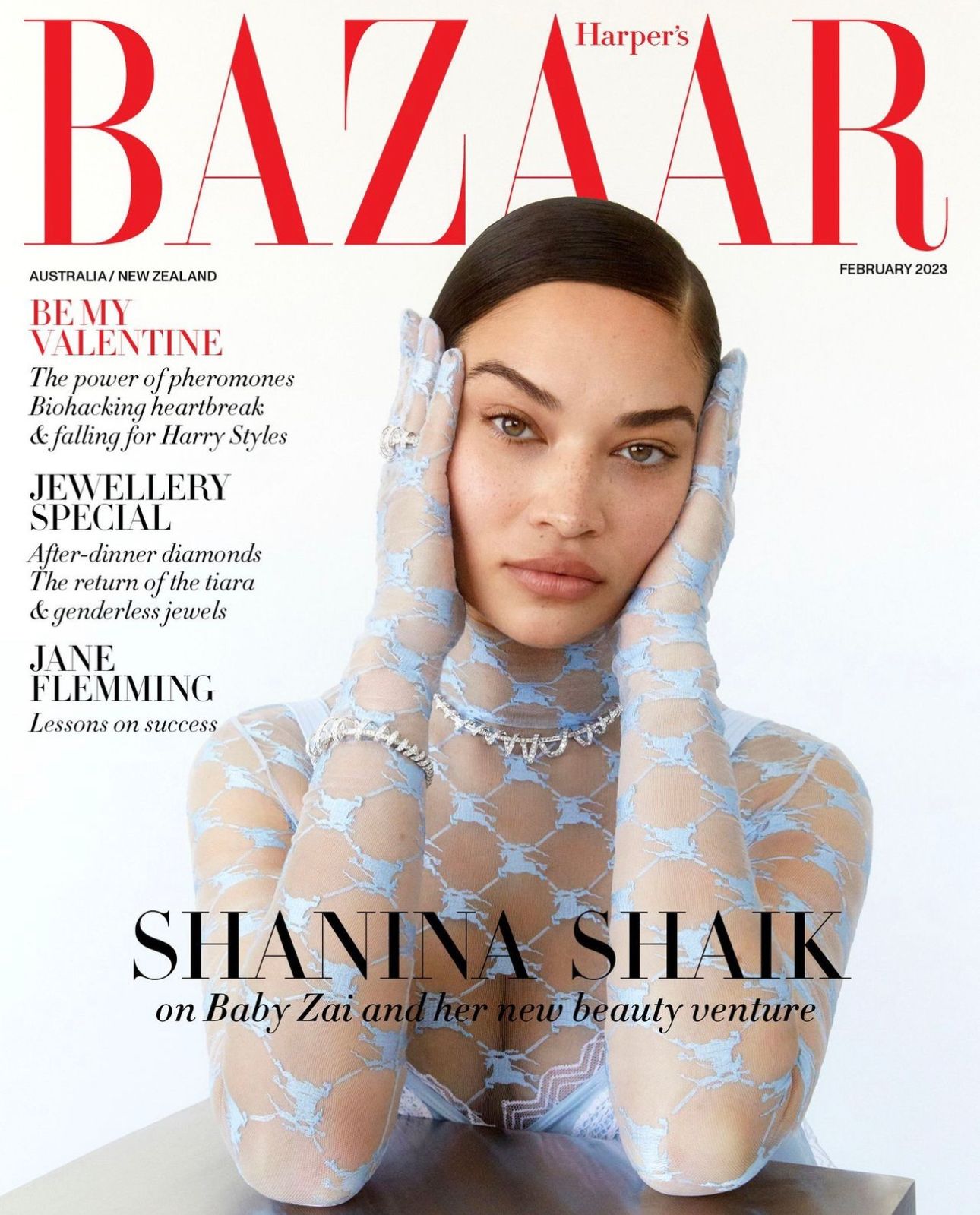 Shanina Shaik cover for Harper's Bazaar Australia/New Zealand February 2023 issue. Close-up shot of the model wearing sheer patterned top and jewellery.