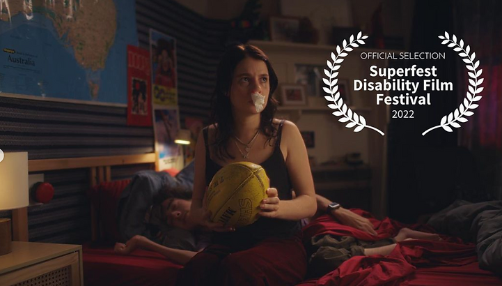 Woman with tape over her mouth sits on a bed with a rugby ball, a figure lies next to her, and an award for a film festival.
