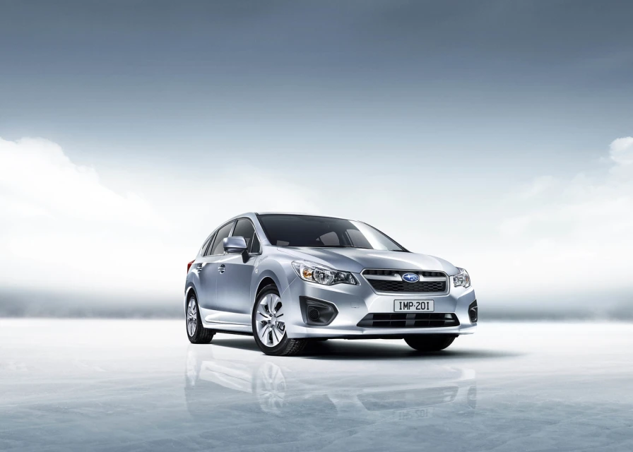 Silver Subaru Impreza stands out in a minimalist automotive studio shot with a light blue backdrop, showcasing its sleek design.