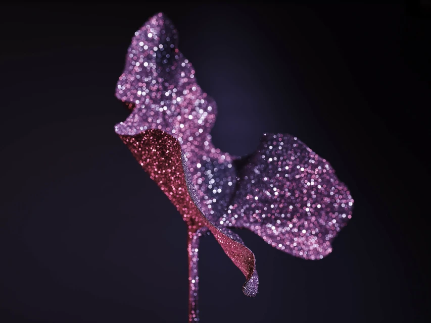 Glitter-covered plant featuring shades of purple and pink against a dark background, creating a shimmering and eye-catching visual.