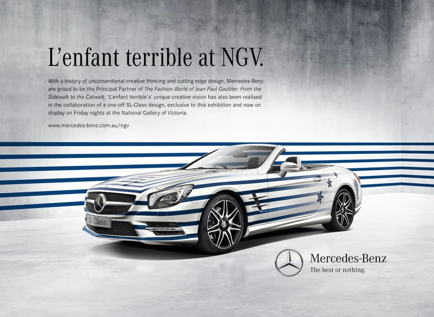Mercedes-Benz SL-Class with Jean Paul Gaultier-inspired blue and white stripe design, displayed in front of a concrete-textured wall.
