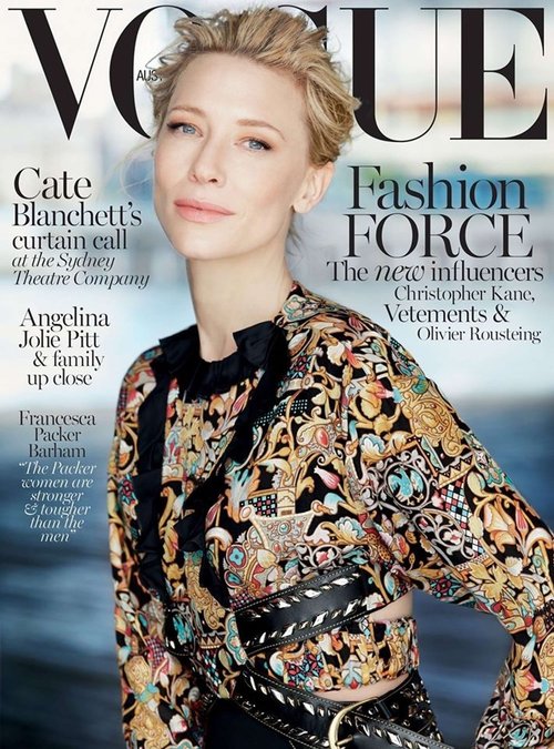 Cate Blanchett graces the cover of Vogue, sporting a patterned top with a black belt, against a blurred outdoor setting.